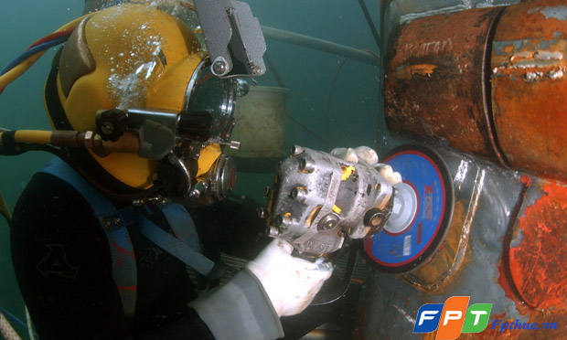 070104-N-3093M-009 San Diego (Jan. 4, 2007) - Navy Diver 1st Class Josh Moore uses a grinder to file down a repair patch on the submerged bow of amphibious transport dock USS Ogden (LPD 5) while the ship was in port at Naval Base San Diego. Murray is a member of the Southwest Region Maintenance Center (SWRMC) Dive Locker's underwater welding team. U.S. Navy photo by Mass Communication Specialist Senior Chief Andrew McKaskle (RELEASED)